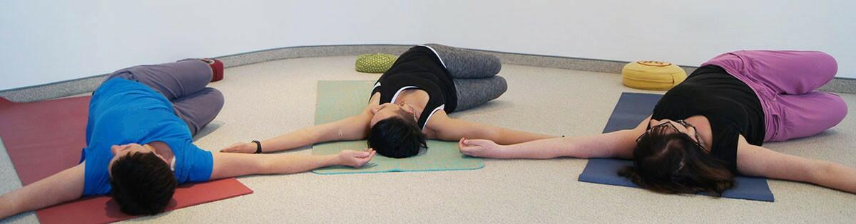 Yoga liegend auf Rücken, Arme ausgestreckt